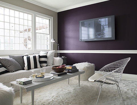 Deep purple accent wall with flat screen TV in a contemporary living room. Deep purple accent wall with flat screen TV in a contemporary living room.