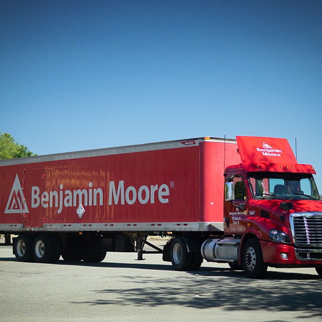 A large, red Benjamin Moore delivery truck. A large, red Benjamin Moore delivery truck.