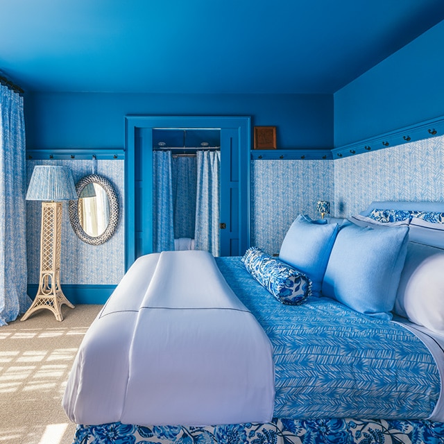 A pretty, blue painted bedroom with blue patterned wallpaper, and blue and white bedding and decor.  A pretty, blue painted bedroom with blue patterned wallpaper, and blue and white bedding and decor.