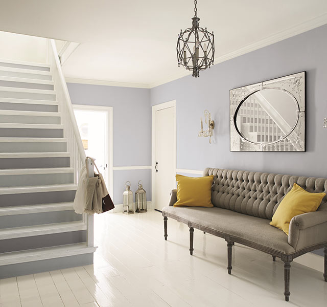 A home foyer with light gray painted walls; a white ceiling, floor, and trim; and an open white staircase with alternating light- and dark-gray painted risers. A home foyer with light gray painted walls; a white ceiling, floor, and trim; and an open white staircase with alternating light- and dark-gray painted risers.