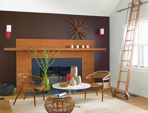 Living room with wide fireplace, purple wall and rolling ladder Living room with wide fireplace, purple wall and rolling ladder