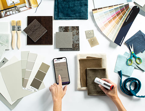 A professional evaluating different paint color swatches and tools to complete their color portfolio. A professional evaluating different paint color swatches and tools to complete their color portfolio.