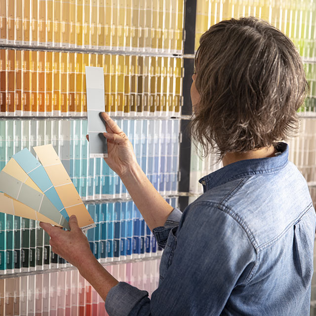 Woman inspecting various paint swatches. Woman inspecting various paint swatches.