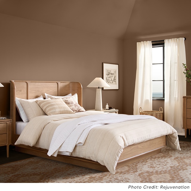 A spacious light brown-painted bedroom with a vaulted ceiling and neutral, modern decor. A spacious light brown-painted bedroom with a vaulted ceiling and neutral, modern decor.