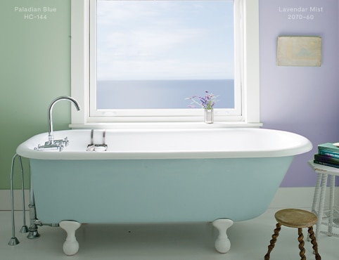 Serene bathroom with light blue clawfoot tub, one green-painted wall and one pastel purple-painted wall.  Serene bathroom with light blue clawfoot tub, one green-painted wall and one pastel purple-painted wall.