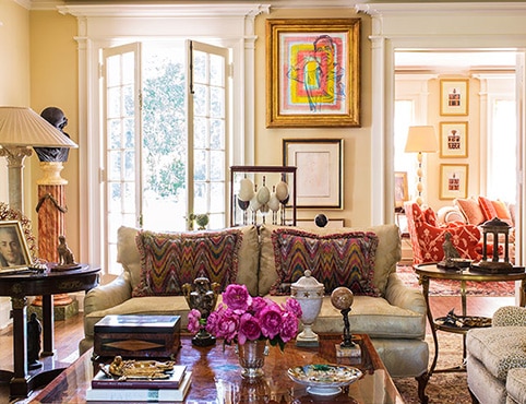 A sitting room with pale yellow-painted walls and ornamental white ceiling, love seat, wood coffee table, antique side tables, and French doors. A sitting room with pale yellow-painted walls and ornamental white ceiling, love seat, wood coffee table, antique side tables, and French doors.